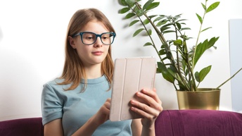 Eine junge Schülerin, die gerade am Tablet lernt.