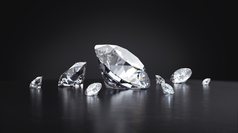Nahaufnahme von verschieden großen Diamanten verstreut auf dunklem Untergrund