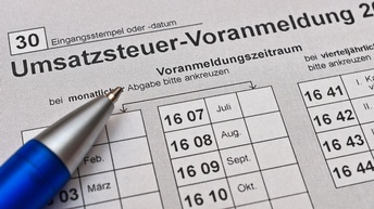 Detailansicht eines Dokuments mit Schriftzug Umsatzsteuer-Voranmeldung und Stiftspitze