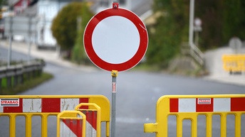 Eine Straßensperre an einer Baustelle: Ein Fahrverbotsschild zwischen gelben Baustellenzäunen.