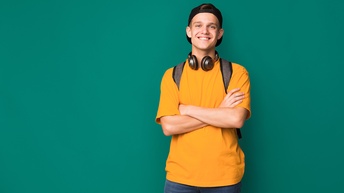 Junger Mann mit verschränkten Armen vor einem grünem Hintergrund
