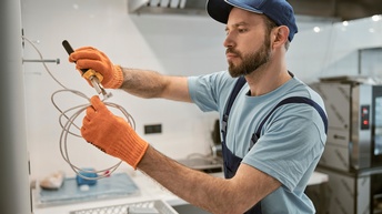 Elektriker repariert ein Kabel mit einer Zange
