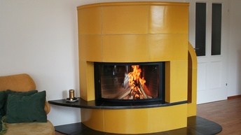 Brennender Kaminofen mit gelber Verfliesung