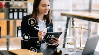 Eine Person sitzt an einem Tisch. In den Händen hält sie ein Tablet. Vor ihr ist ein aufgeklappter Laptop. Overlay diverser Symbole: Über der Person in der Mitte steht AML. Um AML sind verschiedene Symbole angelegt wie Zahnräder, eine Waage, ein Schloss.