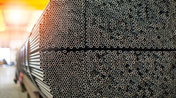 Nahaufnahme sehr vieler, dicht übereinander gestapelter Metallrohre. Der Durchmesser der Rohre ist nicht groß