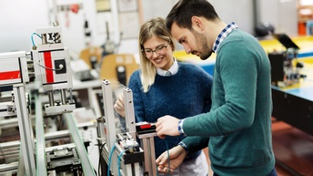 Personen arbeiten gemeinsam an einem Mechatronik-Werkstück