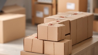 Kartonagen Pakete verpackt und bereit für den Versand stehen auf einem Regal während im Hintergrund weitere Pakete stehen