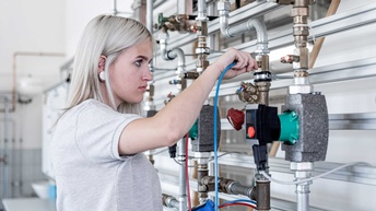 Eine Installateurin bei Montagearbeiten