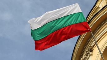 Die bulgarische Flagge steckt an einem historischen Gebäude und weht im Wind.