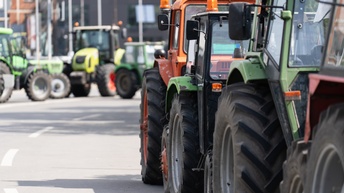Mehrere Traktoren stehen auf einer asphaltierten Straße