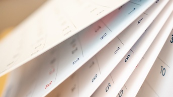 Seitliche Nahaufnahme mehrerer Kalenderblätter hintereinander