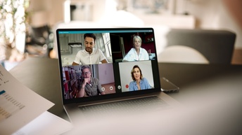 Laptopbildschirm mit vier Personen auf dem Monitor