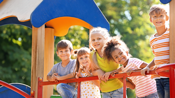 Kleine Kinder stehen auf einem Spielgerät