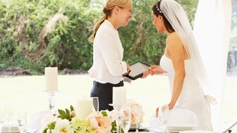 Hochzeitsplanerin spricht mit Braut bei Hochzeit