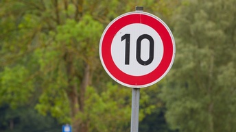 Schild mit Geschwindigkeitsbeschränkung 10, im Hintergrund zeigt