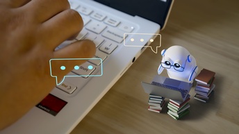Nahaufnahme der rechten Hälfte eines Laptops, auf der die rechte Hand einer Person ist. Neben dem Laptop ist ein sehr kleiner, weißer Roboter, vor dem auf zwei Bücherstapeln ein aufgeklappter Laptop ist. Über dem Roboter ist eine Sprechblase.