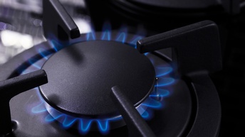 Detailansicht einer Gasherdplatte mit Gasflammen