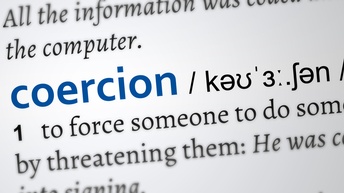 Nahaufnahme des Wortes Coercion, das in blauer Schrift gedruckt ist