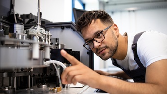 Person mit Brillen inspiziert Maschine