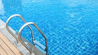 Eine metallene Leiter führt in ein großes Becken, das mit klarem Wasser befüllt ist