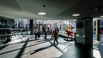 Eingangsbereich der Wirtschaftskammer Österreich mit Menschen, die ein und aus gehen