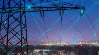 Im Vordergrund im Ausschnitt Strommasten mit blauem Overlay zu Punkten zusammenlaufender Linien ein Netz formend, im Hintergrund Stadtlandschaft im Abendlicht