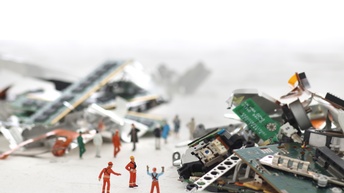 Spielfiguren stehen neben Haufen voller geschredderter Computerplatinen