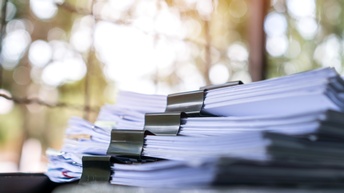 Detailansicht eines Aktenstapels mit schwarzen Klammern 