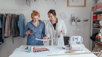 Modedesignerinnen schneidern in einem Studio Kleidung