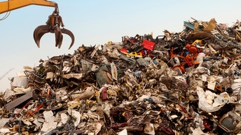 Neben einem sehr großen Berg Müll und Schrott ist eine große Kralle