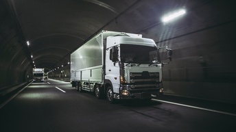 Weiße LKWs fahren durch einen Tunnel