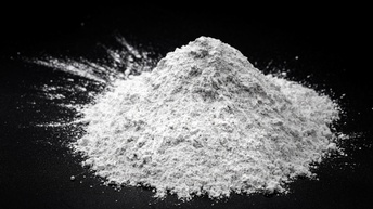 Nahaufnahme eines kleinen Haufens weißen Pulvers auf einem dunklem Untergrund