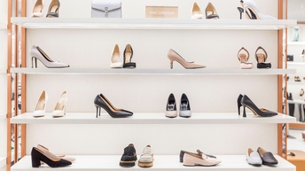 Offenes Regal mit vier Reihen, in denen verschiedene Schuhe platziert sind