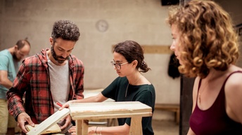 Personen verarbeiten Holz in einer Werkstatt 