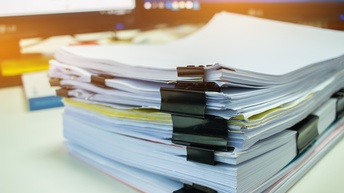 Nahaufnahme eines Papierstapels auf einem Schreibtisch