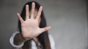 Auf dem Bild ist eine Frau zu sehen, die mit der Hand eine Stopp-Geste macht.