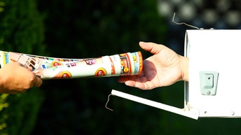 Eine Hand reicht einer anderen Hand ein Bündel an Prospekten