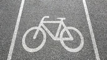 Detailansicht Asphaltstraße mit weißem aufgemalten Fahrradzeichen