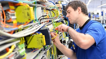 Ein Elektrotechniker bei der Montage von Sicherungen