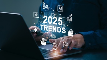 Eine Person tippt auf der Tastatur eines Laptops. Darüber steht 2025 Trends. Um das Wort schwirren verschiedene Symbole wie ein Einkaufswagen, Windräder, eine Person an einem Laptop, ein weißes Kreuz etc.
