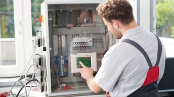 Elektriker programmiert eine Messeinrichtung