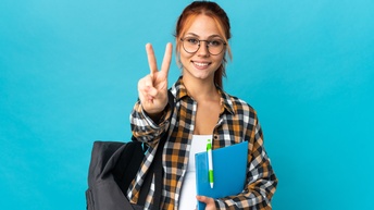 Person mit Brillen in kariertem Hemd mit Rucksack um die Schulter gehängt hält in einer Hand blaue Mappe mit Stift und streckt die andere Hand von sich weg mit ausgestrecktem Zeige - und Mittelfinger, Hintergrund blau