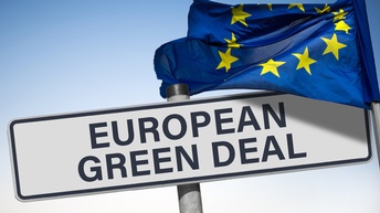 Schuld mit Schriftzug European Green Deal, darüber im Wind wehende Europaflagge