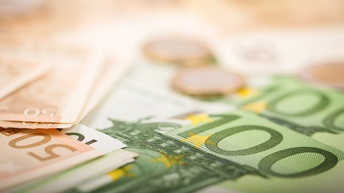 Detailansicht von 100- und 50-Euro-Gelscheinen, zwei Euromünzen verschwommen