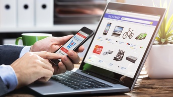 Eine Person hält ein Smartphone in den Händen und kauft online ein