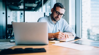 Person sitzt vor Laptop und arbeitet
