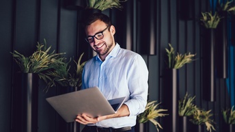 Person sitzt vor Laptop und arbeitet