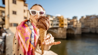 Im Fokus Eistüte mit Schokoladeneis, das Person die es hält über Hand rinnt