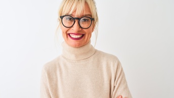 Porträt einer lächelnden Person mit Brillen mit verschränkten Armen