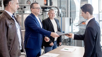 Ein Lehrling der Installations- und Energietechnik bekommt seinen Gesellenbrief überreicht